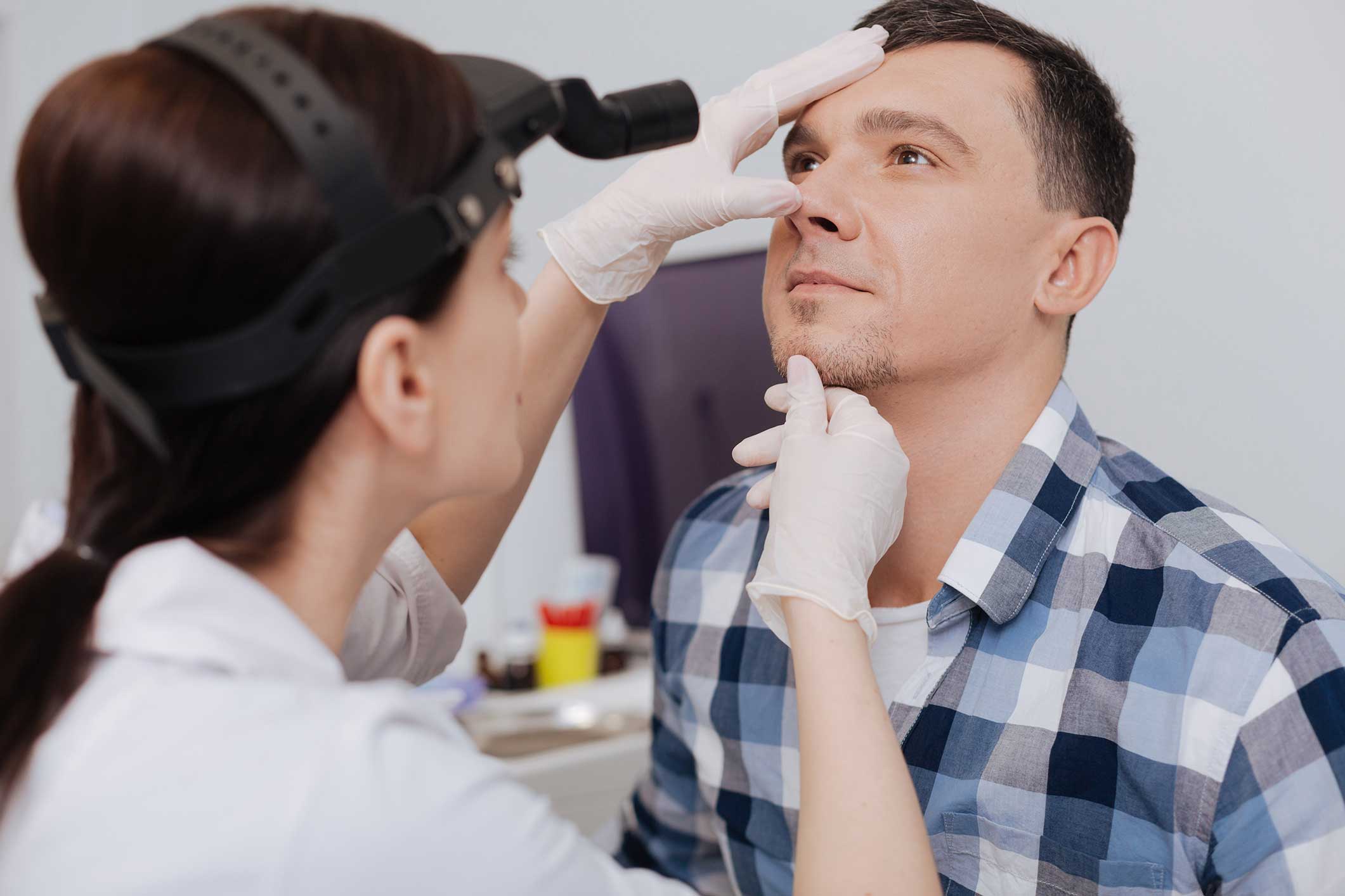 Doctor examining a patient's nose