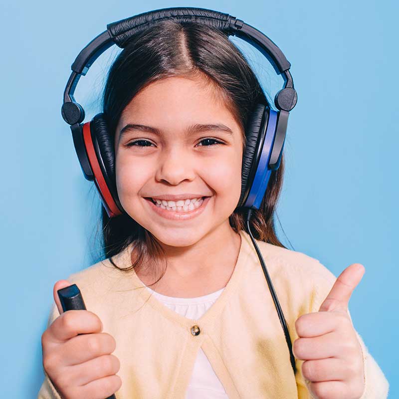 Young girl getting wearing headphones during a hearing test