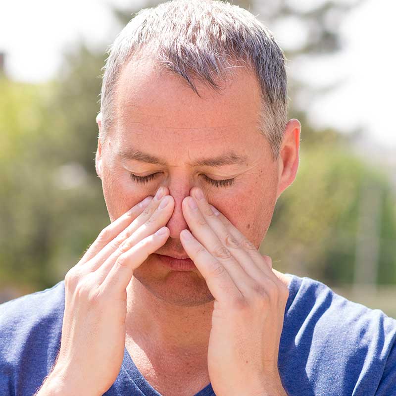 Man holding his nose because of allergies