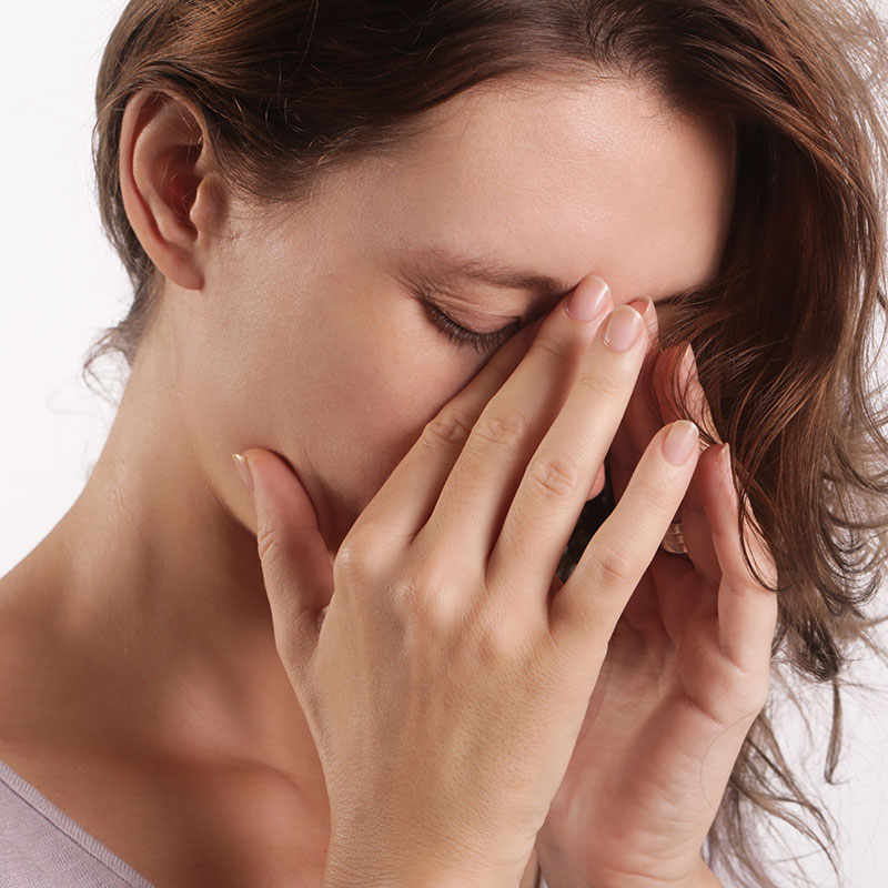 Woman holding her nose and wondering if balloon sinuplasty will relieve her chronic sinus infections