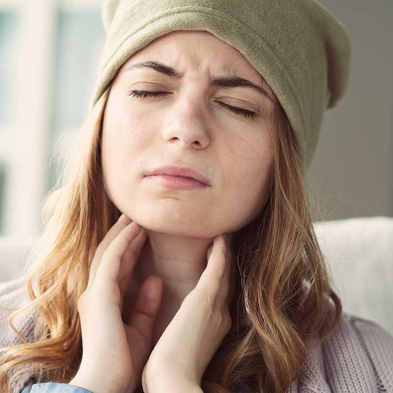 Woman touching her throat and wondering why it keeps getting infected
